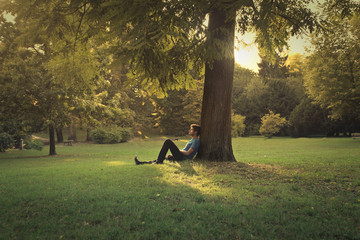 Man sitting under a pine tree