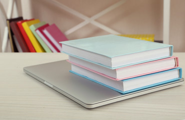 Stack of books with laptop on table close up