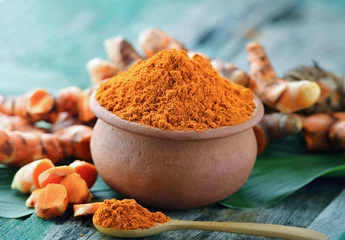 Crédence de cuisine en verre imprimé Herbes turmeric powder in ceramic bowl on wooden background