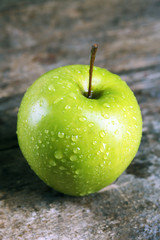 Ripe green apple on wooden table close up
