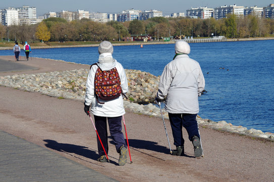 Older women with Nordic walking sticks walking in the park Kolom