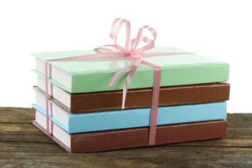 Fototapeta premium Stack of books with ribbon on light background