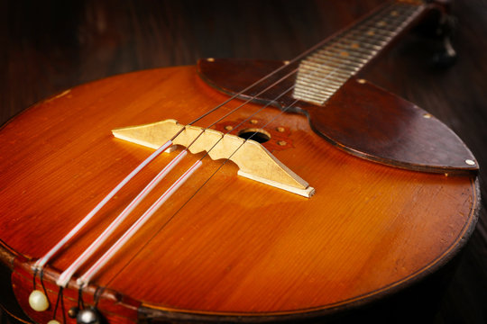 Folk musical instrument domra on wooden surface, closeup