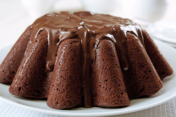 Tasty chocolate muffin with glaze on table close up