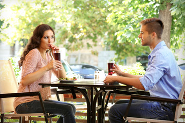 young couple flirting on cafe's summer terrace