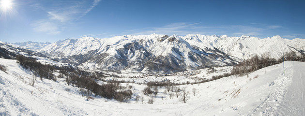 Naklejka premium Panoramic view down a snowy mountain valley