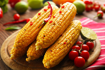 Grilled corn served with vegetables on rustic round plate