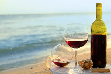 Wine bottle and glasses on the seashore
