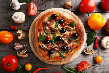 Delicious heart shaped pizza with vegetables on wooden background, close up