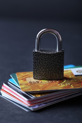 Concept of saving money - lock with credit cards on black background