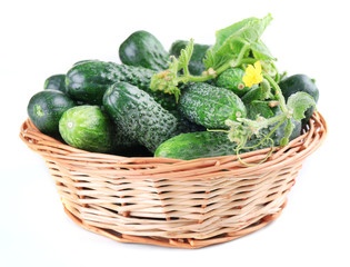 Wicker basket with cucumbers isolated on white