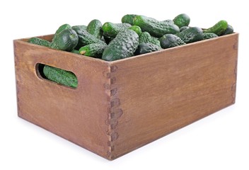 Ripe cucumbers in wooden box isolated on white