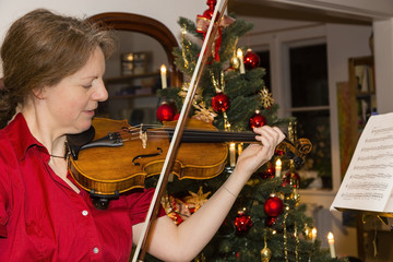 Frau musiziert auf einer Geige zu Weihnachten, woman is playing violin at christmas
