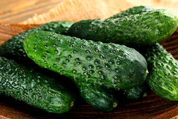 Fresh cucumbers in rustic bowl on  wooden background