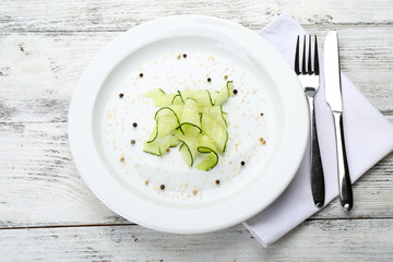 Sliced cucumbers dish on white plate in the restaurant, close up