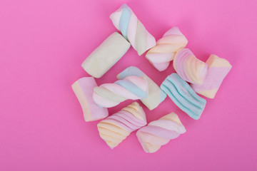 marshmallow candies of different colors on the background of pink. top view. entertainment for children in celebration.