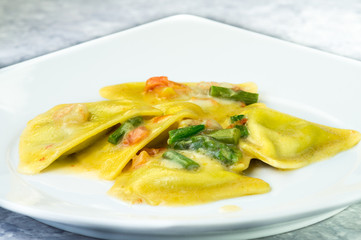 Ravioli di pesce con asparagi e gamberetti, piatto in primo piano