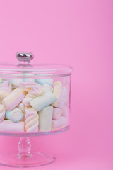 marshmallow candies of different colors on the background of pink. top view. entertainment for children in celebration.