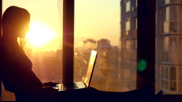 Beautiful young brunette business woman working on her laptop