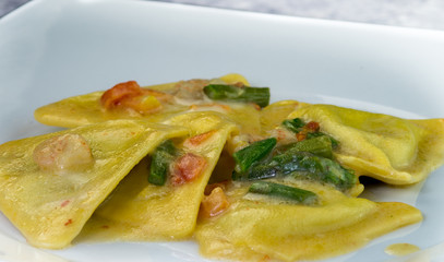 Ravioli di pesce con asparagi e gamberetti, piatto in primo piano