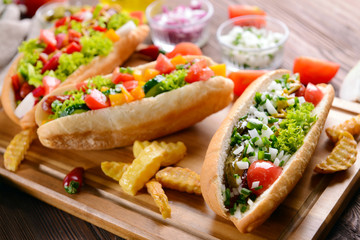 Hot dogs and vegetables on wooden cutting board