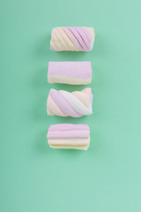 marshmallow candies in different colors on the background of turquoise. top view. entertainment for children in celebration.