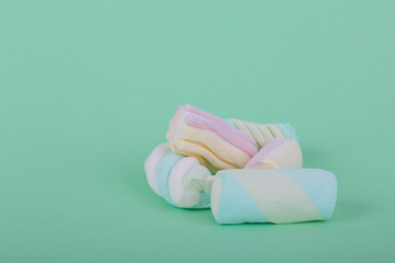 marshmallow candies of different colors in the glass on the background of turquoise. top view. entertainment for children in celebration.