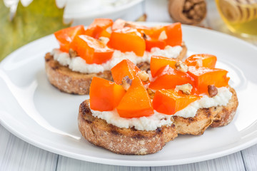 Cottage cheese-persimmon crostini, garnished with honey and walnuts