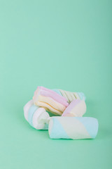 marshmallow candies in different colors on the background of turquoise. top view. entertainment for children in celebration.