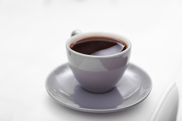 Cup of coffee on sofa in room