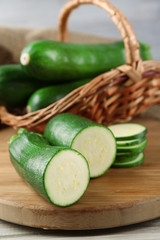 Fresh sliced zucchini on cutting board, on wooden background