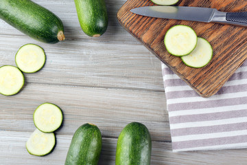 Fresh sliced zucchini on cutting board, on wooden background