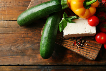 Fresh ingredients for preparing zucchini rolls on wooden background