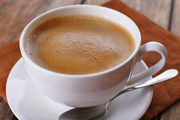 Cup of coffee on brown napkin closeup