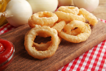 Chips rings with sauce and onion on cutting board closeup