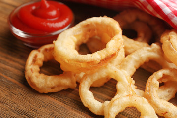 Chips rings with red sauce on wooden background closeup