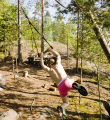 little cute boy flying on bungee among trees