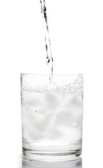 soda water pouring into Glass on White background