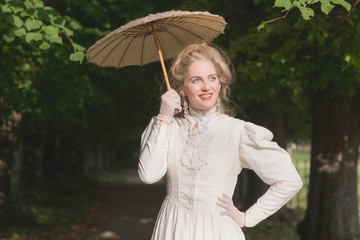 Posh victorian woman with parasol in garden. © ysbrandcosijn