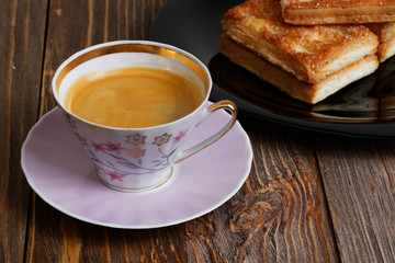 Cookies and cup of coffee on the dark wooden table