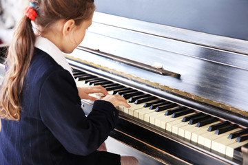 Attractive little girl plays piano