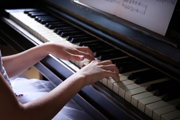 Fototapeta premium Close up of little girl hands piano playing