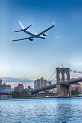 Plane in landing over Brooklyn Bridge