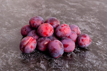 Fresh Dark Plums on black Table