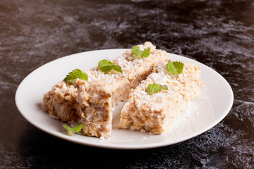 oat bar with coconut with mint on a plate, close up, horizontal
