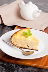 piece of cottage cheese pie with mint on a plate, closeup
