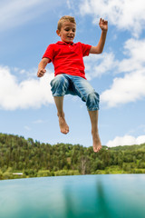 Young boy jumping on trampoline