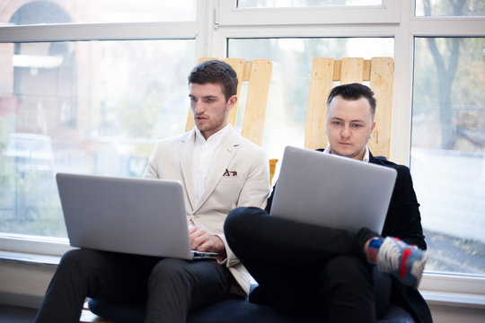 Men using laptops in startup center