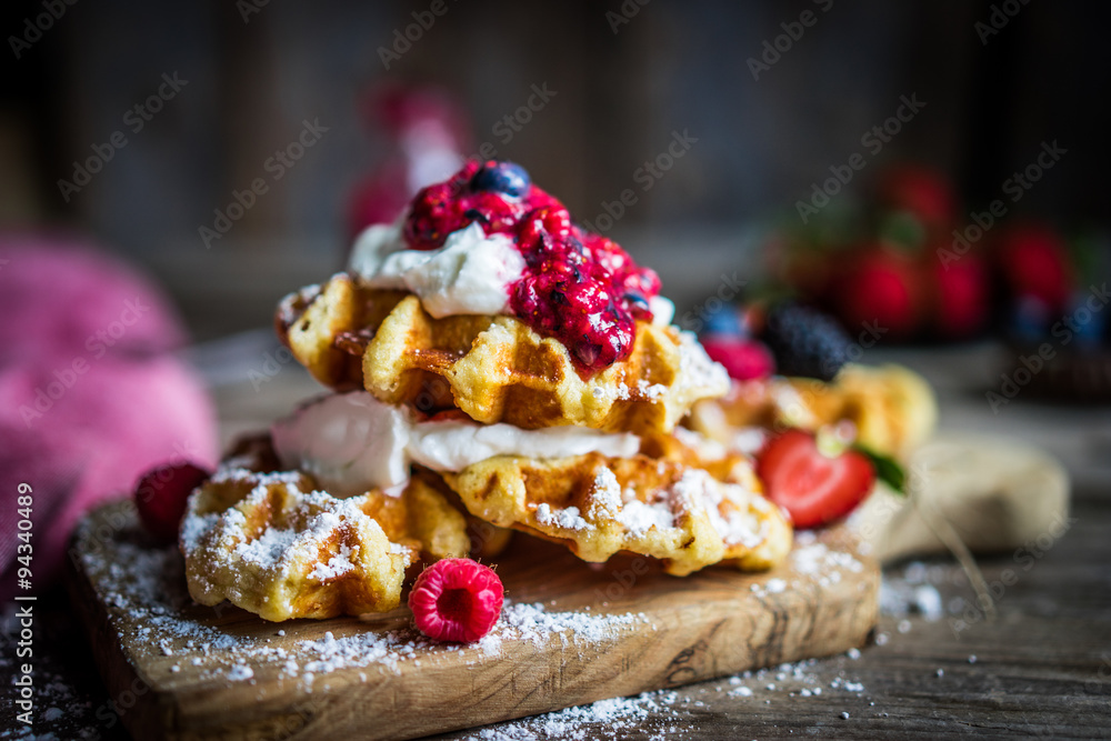 Wall mural belgian waffles with fresh berries on rustic wooden background