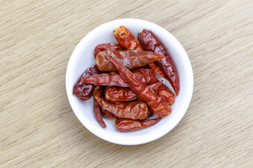 Dry red chili in white bowl on wooden table